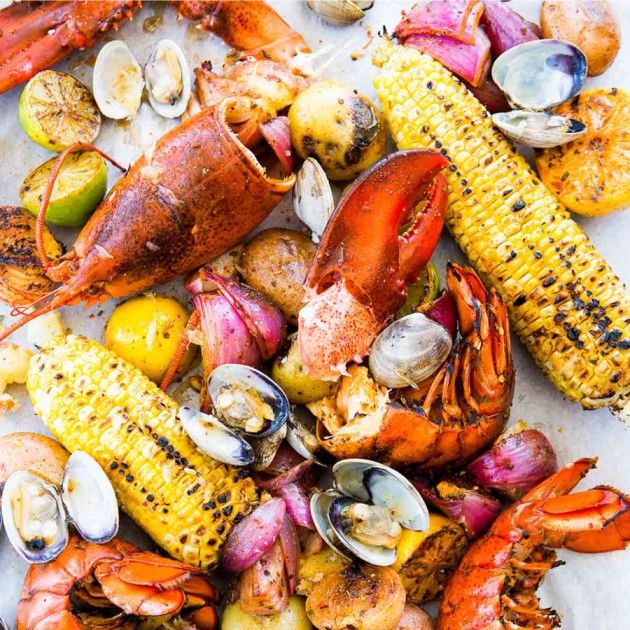 A New England clambake spread with lobsters, clams, and corn