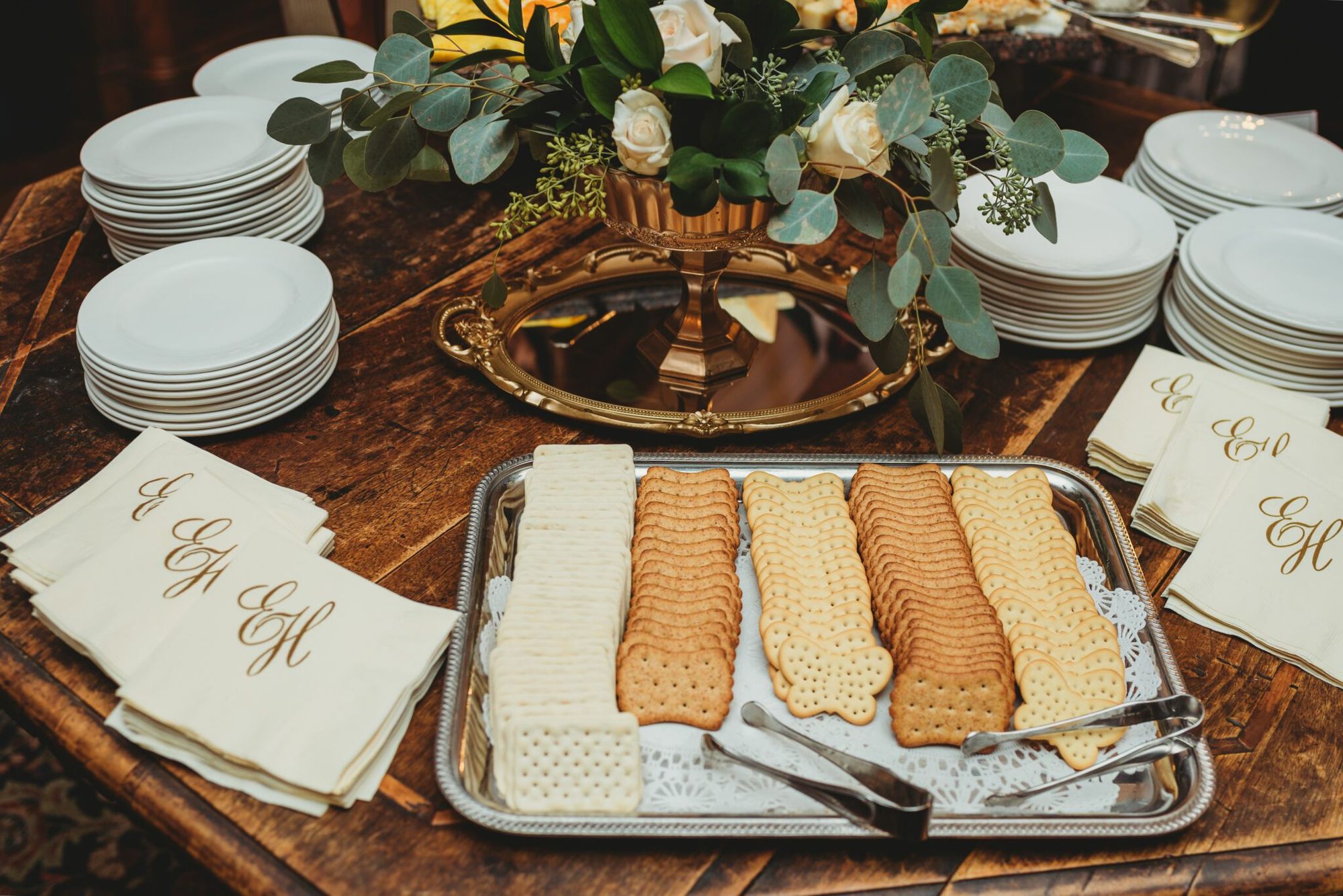 Cocktail hour details — stacked plates, monogrammed napkins, and hors d'oeuvres