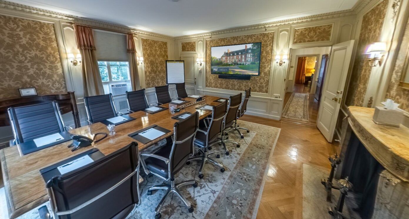 The Killian Suite boardroom with leather chairs and gold wallpaper
