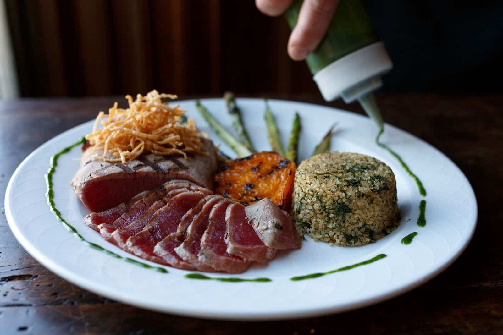 The chef finishing a seared tuna plate